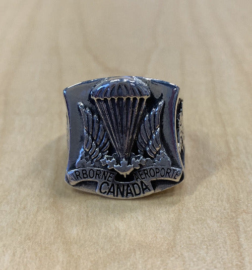 Silver ring with the airborn regiment crest and words AIRBORN CANADA AIROPORTE" below it.