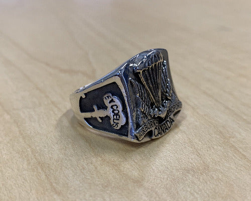 Side view of the airbornr ring with text "ex cœlis" within the crest.