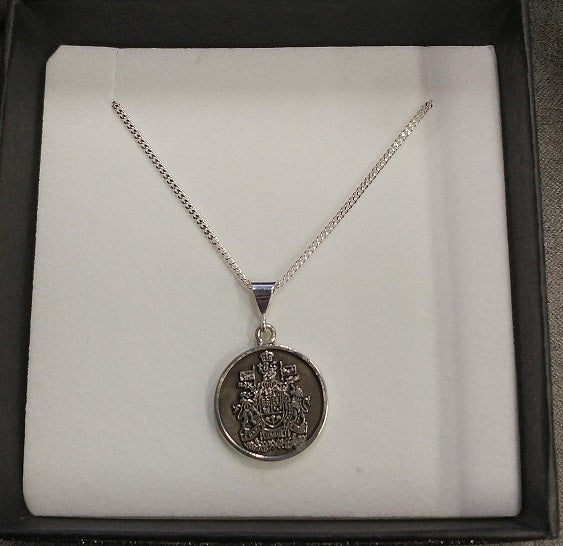 Round  sterling silver pendant charm with the Chief Warrant Officer crest embosses within a ring of black oxidation. The charm is hanging from a thin silver necklace chain.
