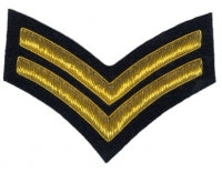Gold embroidered corporal rank on black background.