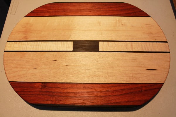 Oval shapped cutting board with dark and light wood