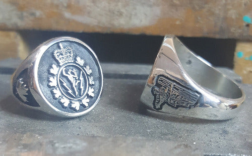 Silver ring with C&E Crest on the face and maple leaf on shoulder. A second ring shoes the lineman on a pole engraved into the shoulder.
