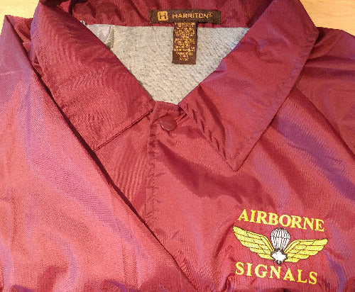 Close-up of Maroon jacket with embroidered Ariborn signals in yellow and jump wings with white maple leaf.