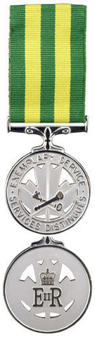 Front and back face of the Corrections Exemplary Service Medal, also shown is the green and yellow ribbon.