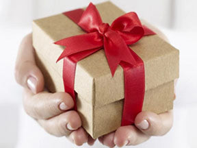 Hands holding a brown box wrapped with a red bow.