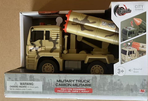 Tan toy military truck with launchers in packaging, showing warning label.