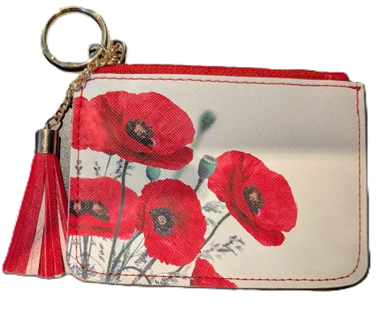 A small zippered card holder or coin purse with a red poppy floral print on a light background, featuring a red tassel and gold key ring.