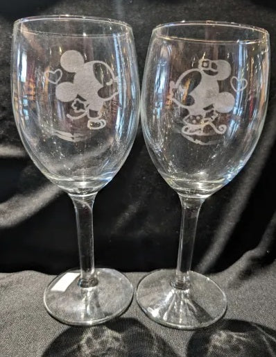 Pair of wine glasses with Mickey and Minnie Mouse facing each other to kiss
