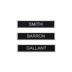 Three examples of black plastic DEU name tags. The names on the tags are Smith, Barron, and Gallant.