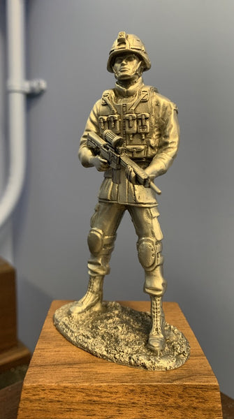 Statue of soldier wearing helmet and holding gun, come with base.