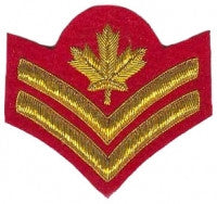 Gold embroidered master corporal rank on red background.