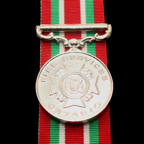 Silver front face of the Ontario fire services medal, also featured is the red, green and white ribbon