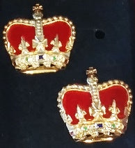A pair of gold metal crowns with red on the inside.