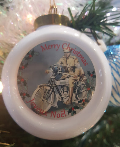 White chistmas ornament with the image of a dispatch rider in the center; the text says "Merry Christmas" "Joyeux Noel"