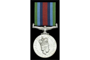 Front face of the osm sierra leone medal, and green, light blue, dark blue, and red ribbon.